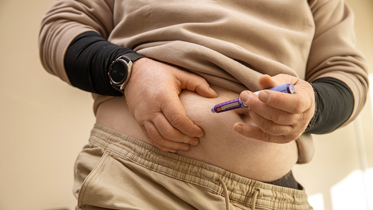 Man is given to the semaglutide injection in the belly. No face is shown, only torso.