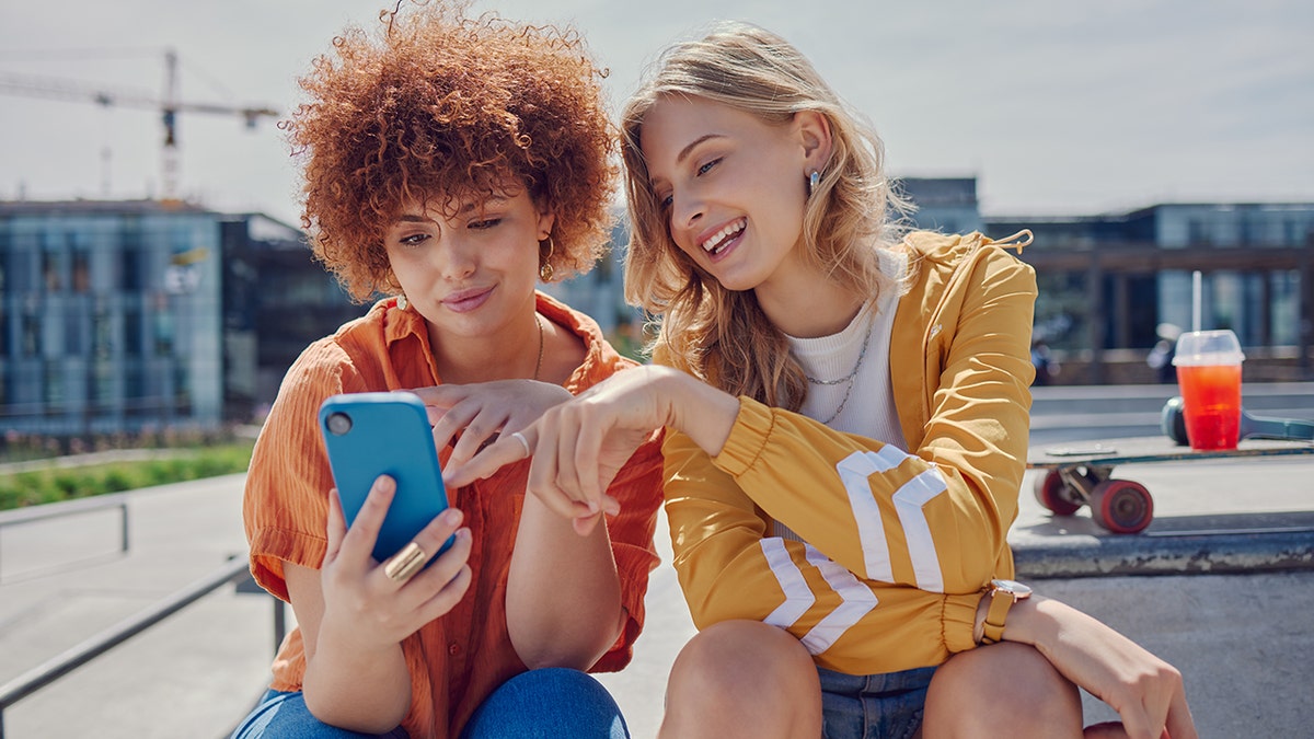 Two friends watching his phone