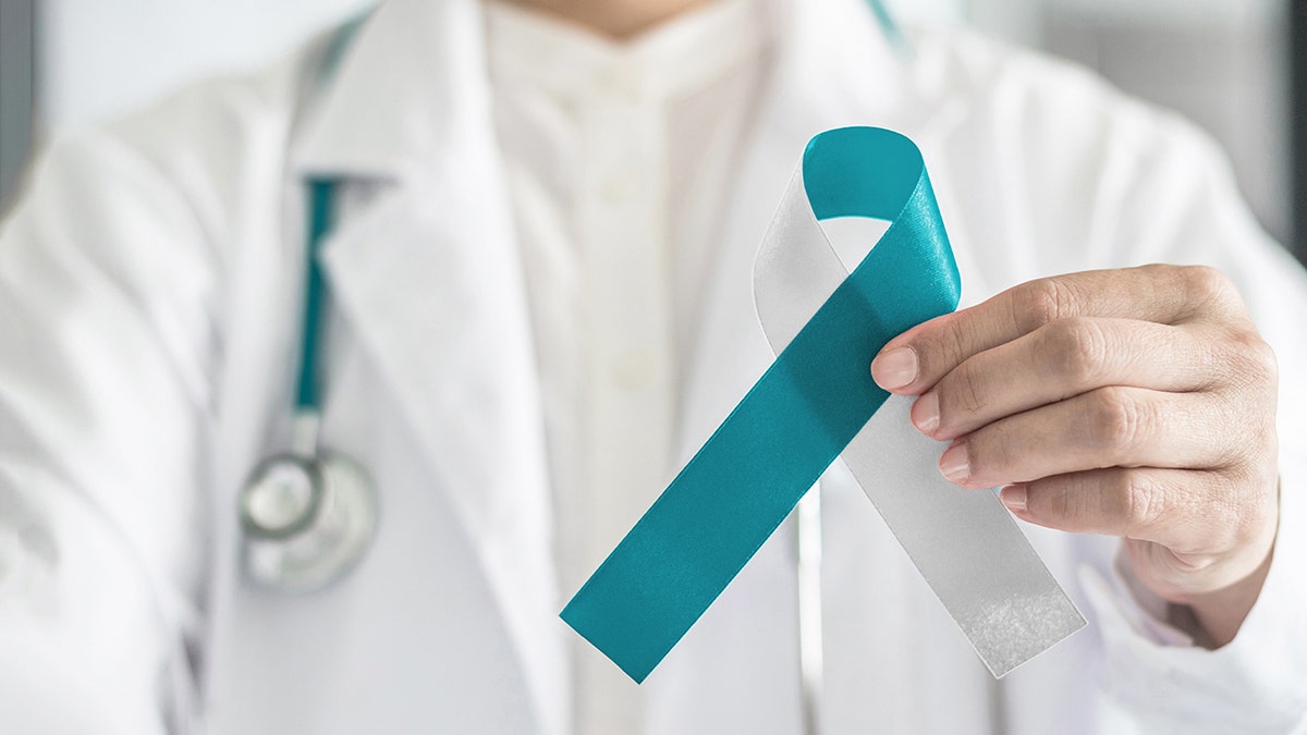 The doctor has a white ribbon for consciousness of cervical cancer
