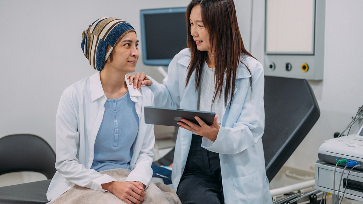 A female gynecologist who talks to his patient about the awareness of cervical cancer and the results of the tests on an electronic tablet.