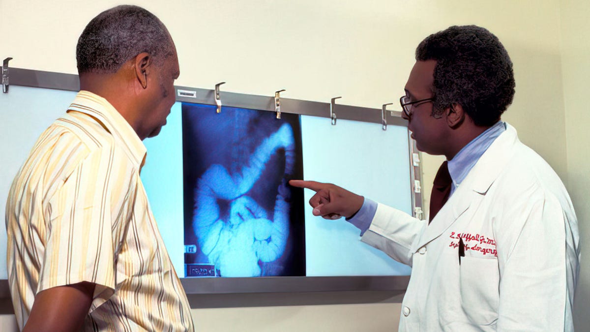 A doctor passes over the x -ray of a patient, who is screened by colon cancer.