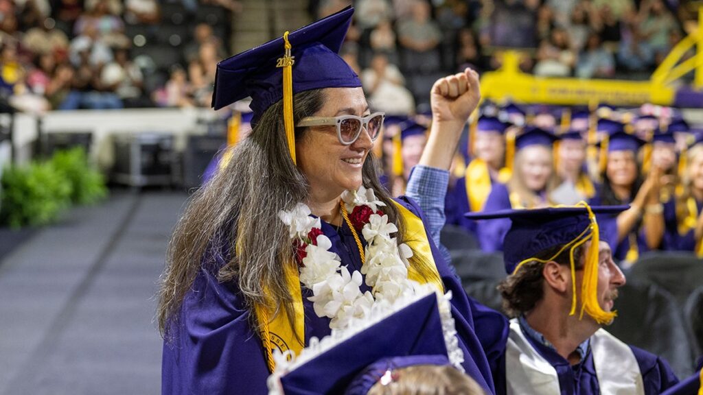 Blind mother of 5 university graduates with honors next to her guide dog