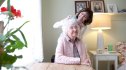 Woman brushing the hair of the older woman; Caretaker cream
